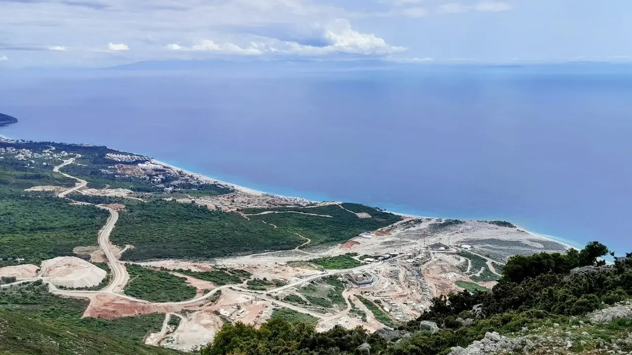 The SH8 coast road descending from the Llogara Pass toward the turquoise Ionian bays of the Albanian Riviera