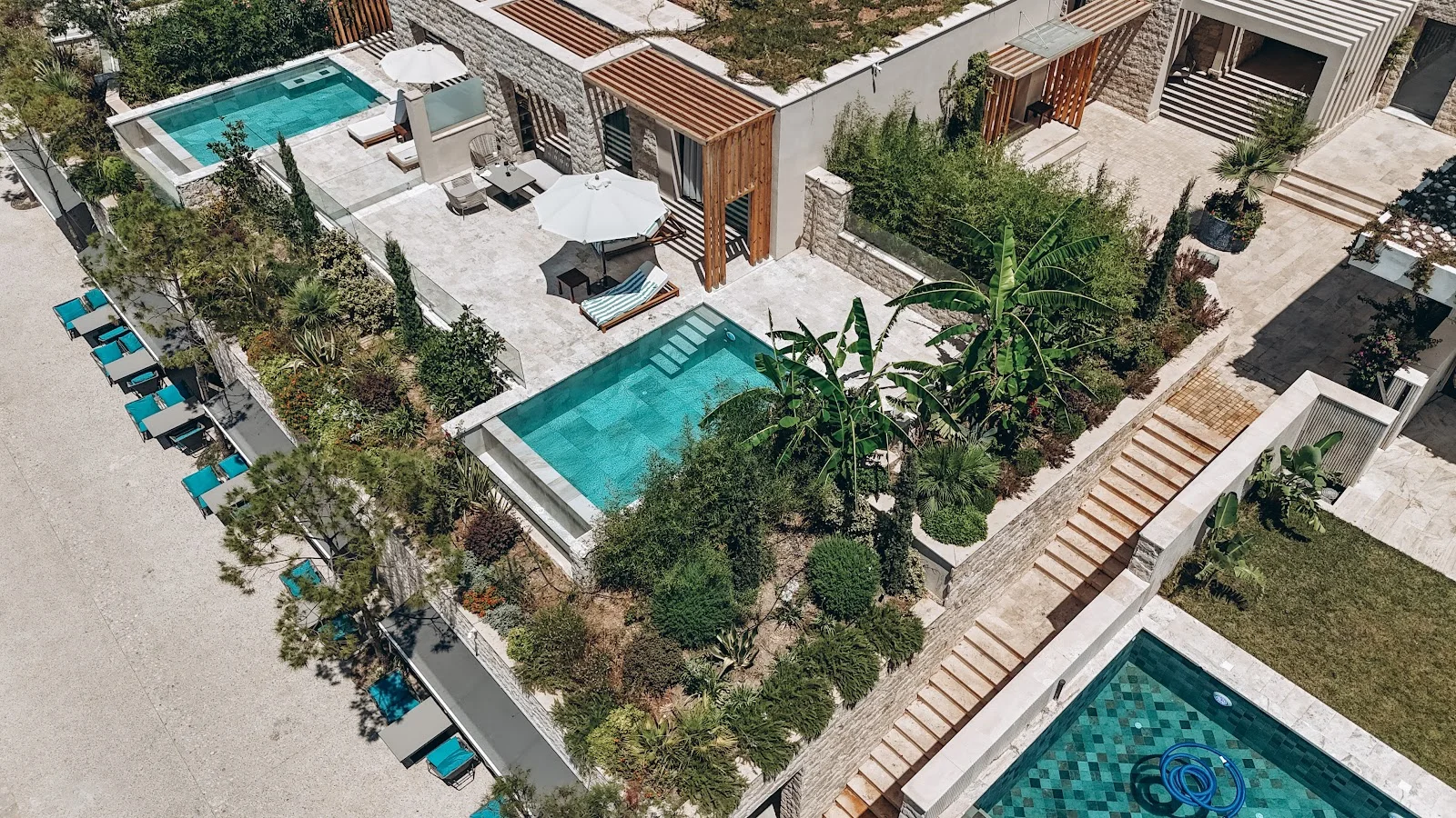 The terraced pools and stone villas of Drymades Inn Resort above the cove at Drymades