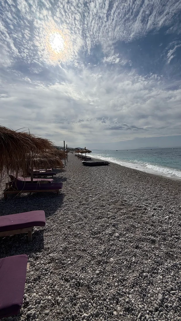 A seafront taverna table set with grilled fish and small plates at Dhërmi