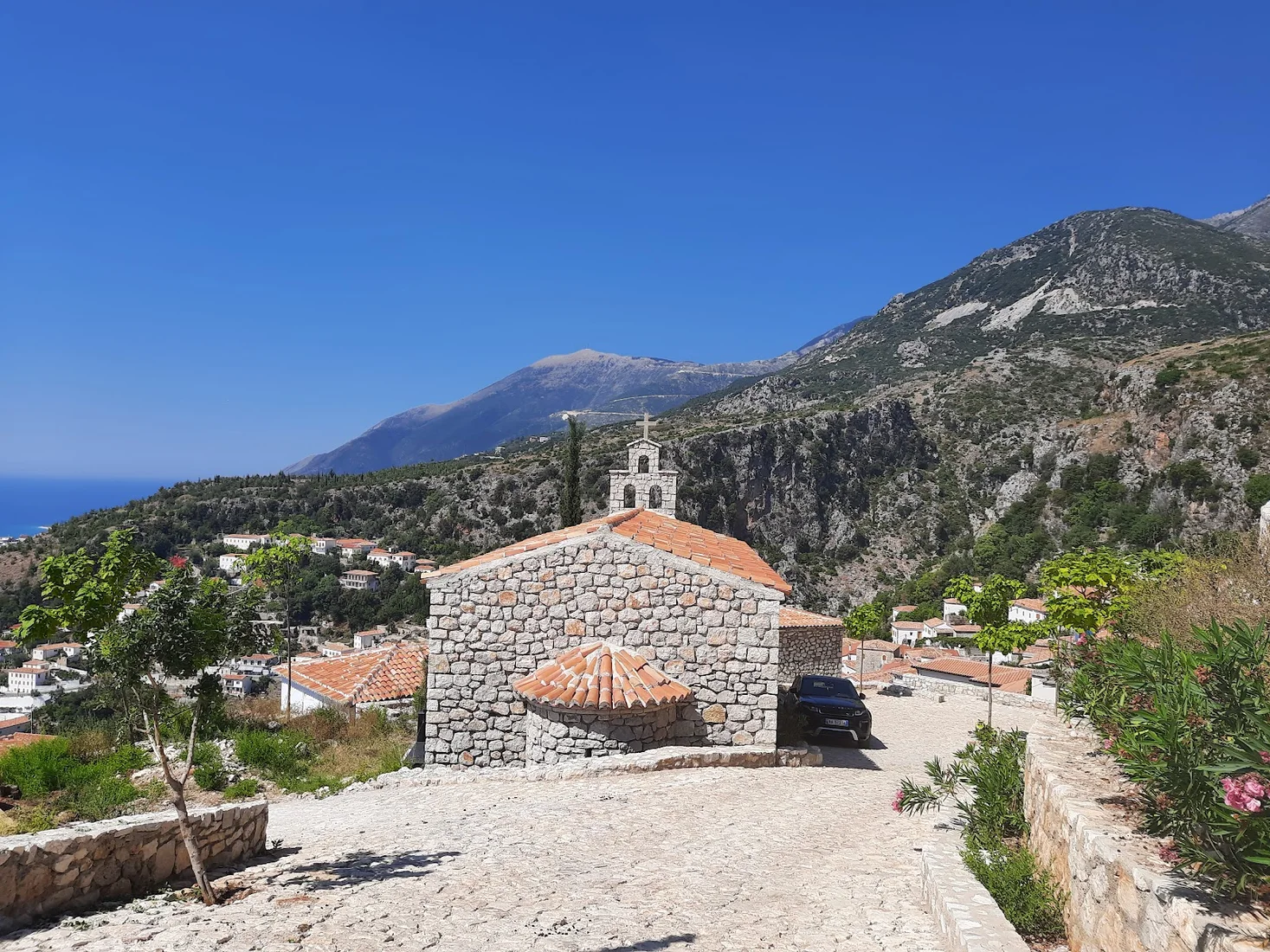 The stone church and bell tower of St. Mary's Monastery above Dhërmi