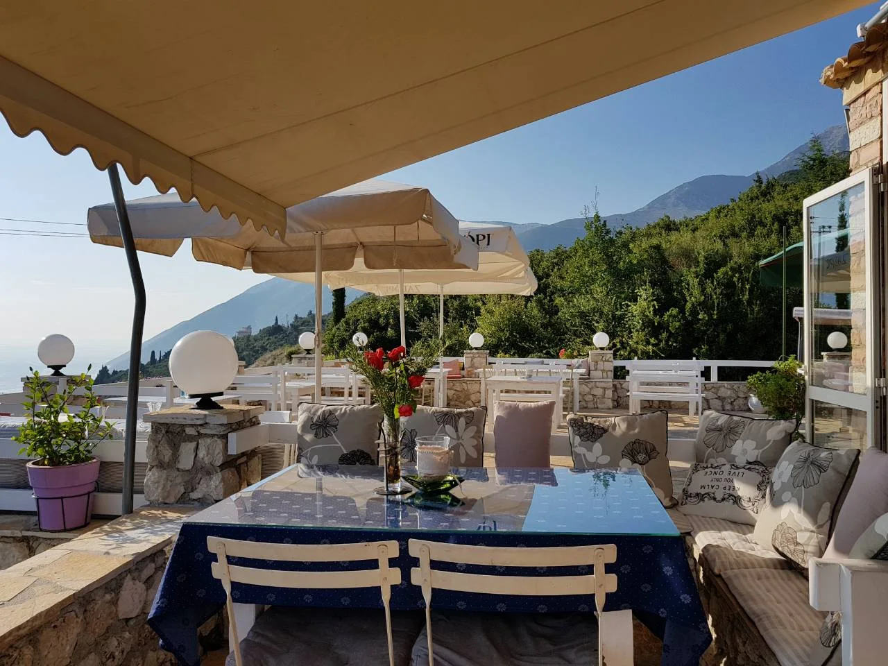 The shaded terrace of Taverna Fevan above the coast road in Dhërmi