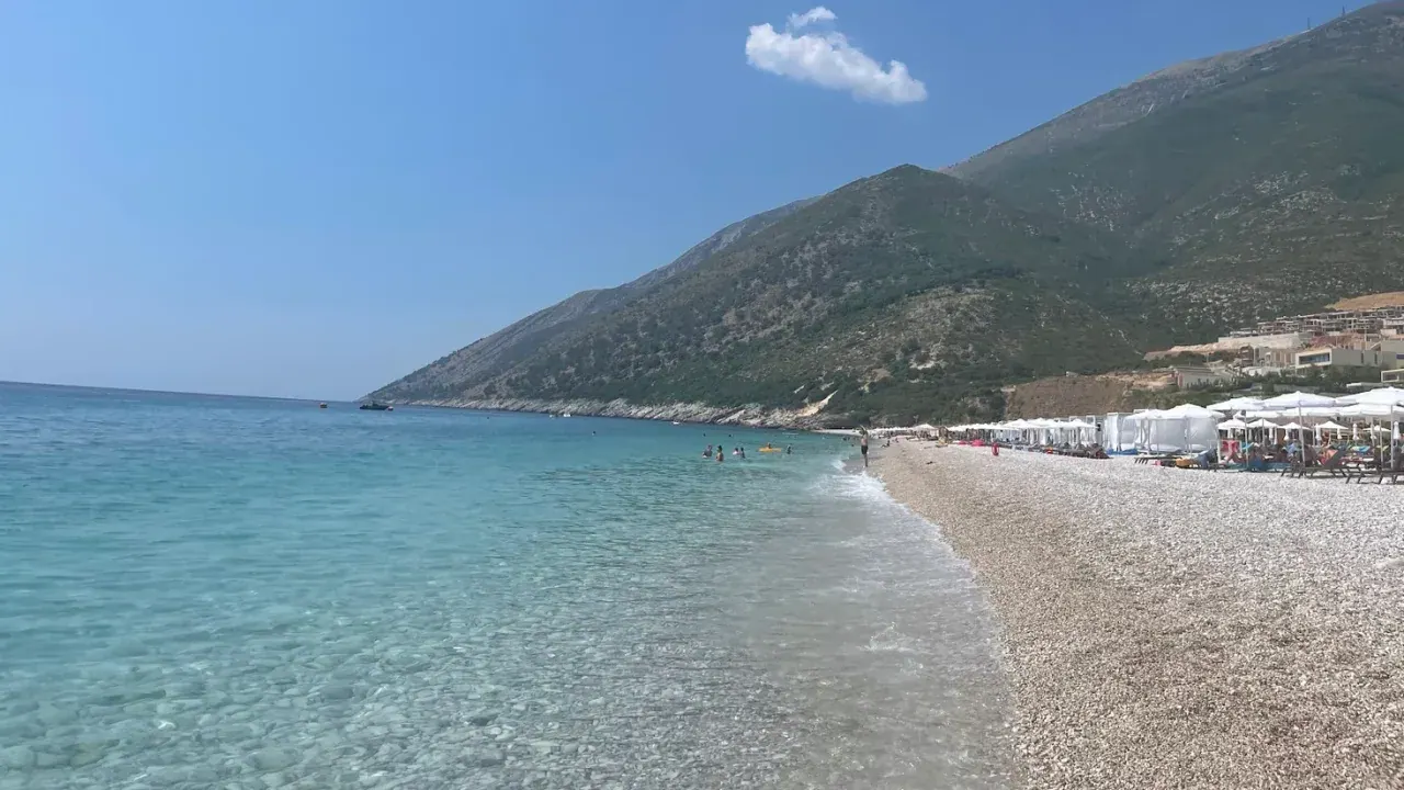 White-pebble Ionian beach and clear turquoise water on the Dhërmi–Palasë shore