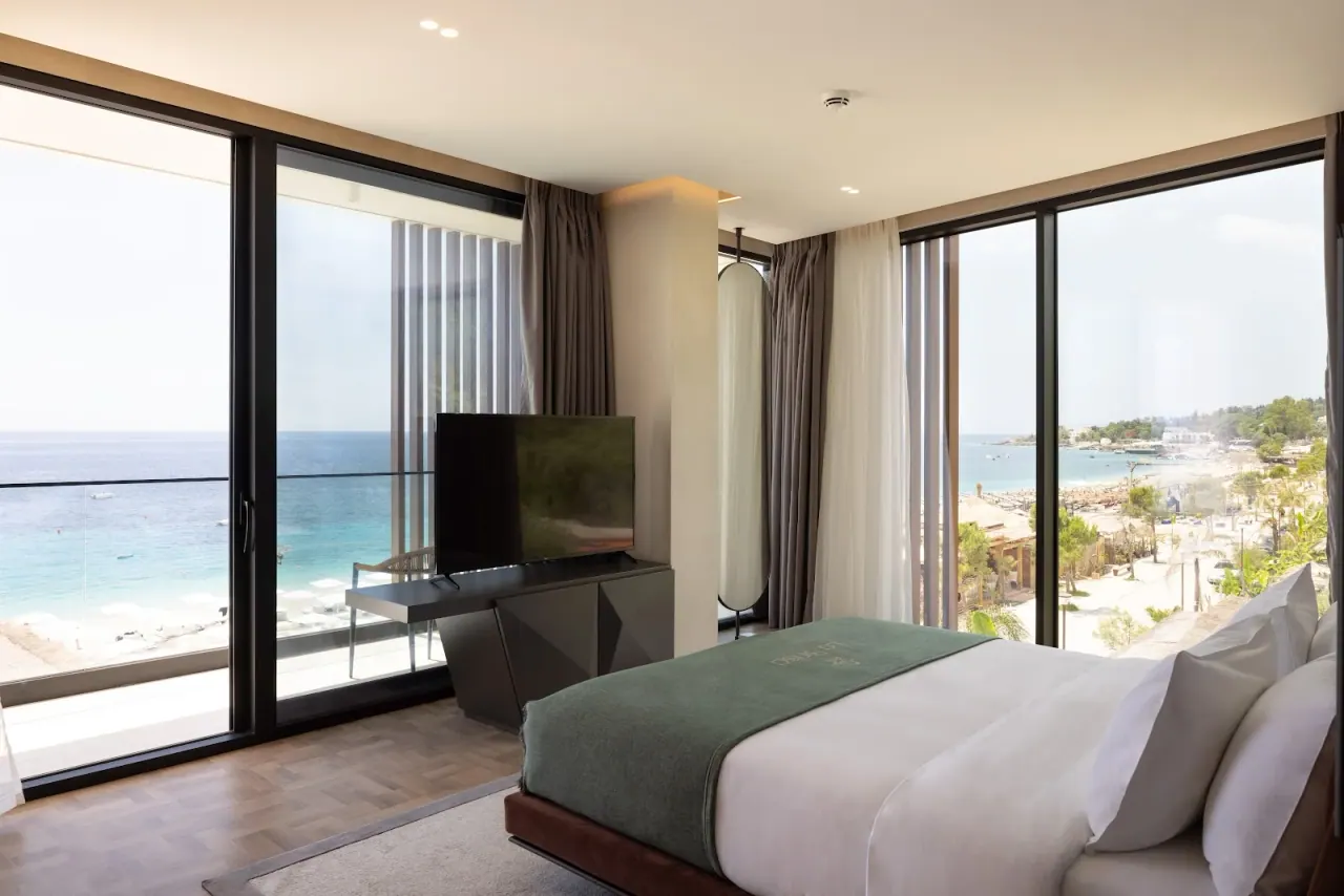 A contemporary beachfront hotel with a pool above the turquoise water at Dhërmi on the Albanian Riviera