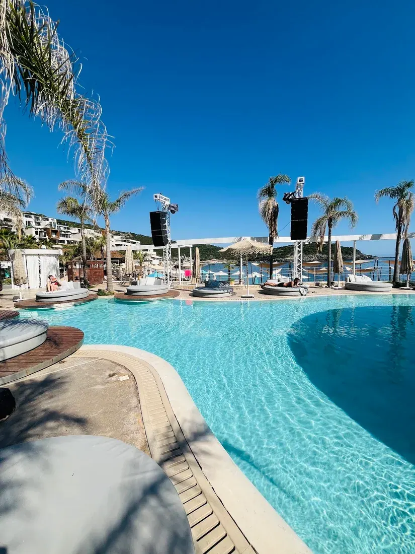Round poolside daybeds and DJ speaker stacks at Folie Marine beach club at Jale