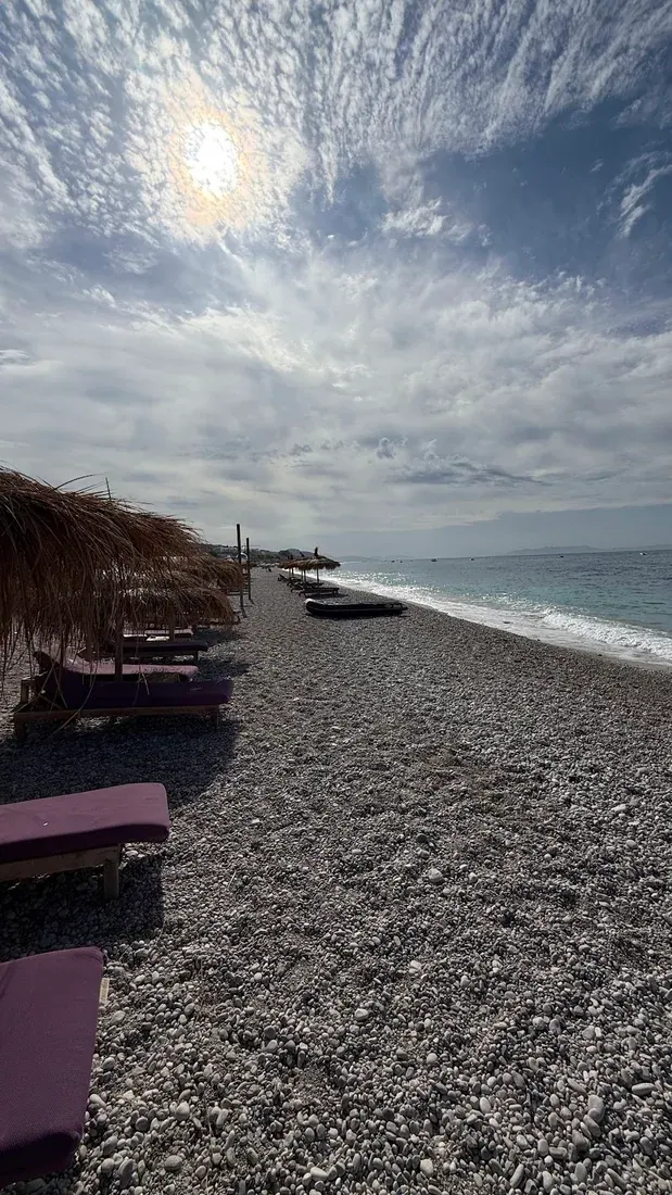 Sunbeds and thatched umbrellas along the Drymades strip