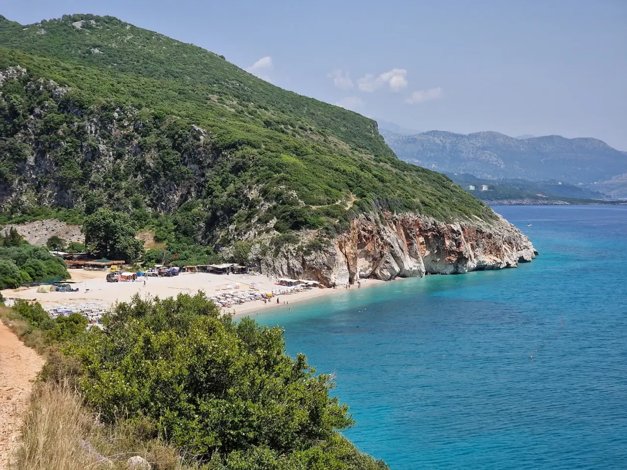 The turquoise cove and cliffs of Gjipe Beach at the mouth of a canyon