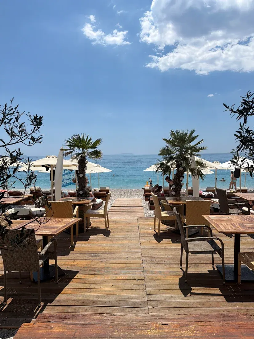 The beachfront boardwalk and sunbeds at Aloni beach club on Dhërmi Beach