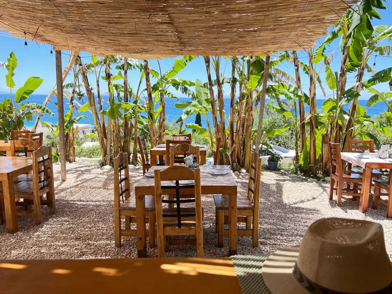 The reed-canopied, banana-palm terrace with a sea view at Grill House Amici, Dhërmi