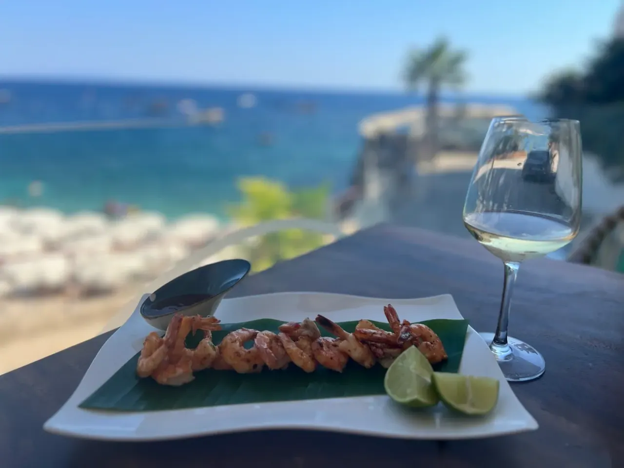 Grilled prawns and a glass of wine overlooking the sea at Noah on the Beach, Dhërmi