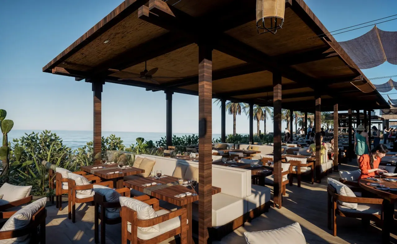 The dark-wood, sea-facing dining pavilion at SALT Green Coast in Palasë, with cushioned banquettes and palms over the Ionian